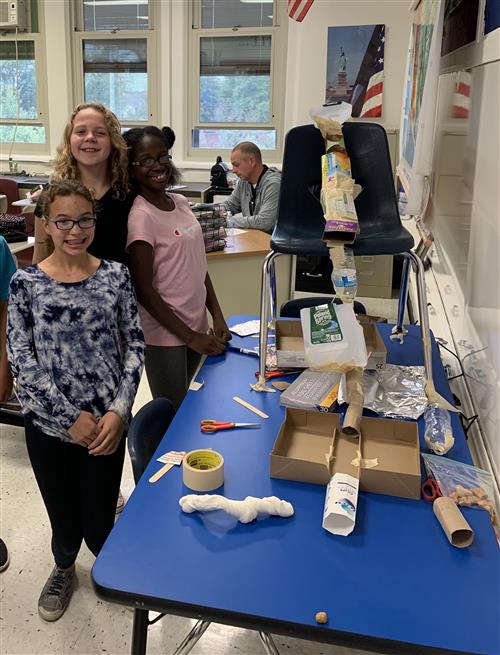 Students posing with Rube Goldberg machines 